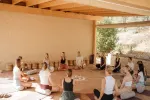 Gruppe sitzt im Kreis während eines Workshops in einem Holzraum