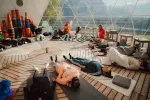 Innenansicht einer Kuppel mit Menschen beim Yoga und Entspannen