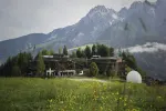 Landschaft mit einem modernen Gebäude und Bergen im Hintergrund