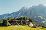 Alpenlandschaft mit Gebäude und Bergen im Hintergrund