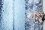 Person schwimmt in einem Pool mit Wasserspritzern