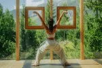 Frau macht Yoga zwischen zwei Fenstern in der Natur
