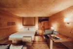 gemütliches Holzinterieur eines Hotelzimmers mit Bett und Sitzecke