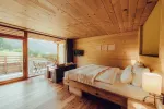 modernes Holzschlafzimmer mit großen Fenstern und Bergblick