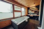 modernes Badezimmer mit Badewanne und großen Fenstern