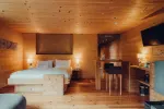 Holzschlafzimmer mit zwei Betten, einer Bar und warmem Licht