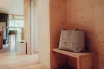 Innenraum eines modernen Raums mit einer Holzbank und einer Tasche darauf