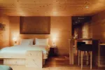 gemütliches Holzschlafzimmer mit einem großen Bett und kleiner Bar