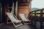 Holzbalkon mit zwei Liegestühlen