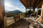 Holzbalustrade mit Stühlen mit Blick auf eine bergige Landschaft
