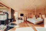 geräumiges Hotelzimmer mit Holzboden und großem Bett