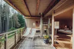Holz-Balkon mit Liegestuhl mit Blick auf Bäume