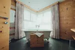 Heller Badezimmer mit freistehender Badewanne und Holzdetails