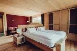 modernes Schlafzimmer mit Holzmöbeln und großen Fenstern