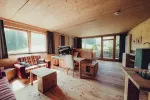 gemütliches Interieur mit großen Fenstern, Holzboden und Sitzbereich