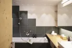 modernes Badezimmer mit Badewanne, Dusche und Holz arbeitsplatte