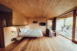 moderne Holzzimmer mit großem Bett und Sitzbereich
