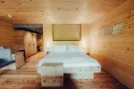 Holzinterieur eines Schlafzimmers mit einem großen Bett und sanfter Beleuchtung