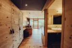 Innenansicht eines Holzraums mit Badezimmer und großen Fenstern