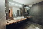 modernes Badezimmer mit Holzarbeitsplatte und großen Spiegeln