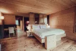 Holzschlafzimmer mit einem großen Bett und minimalistischer Einrichtung
