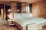 Modernes Schlafzimmer mit Holzwänden und einem großen Bett