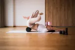 Person, die drinnen Yoga auf einer Matte macht