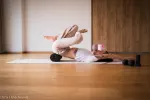 Person übt Yoga auf einer Matte drinnen