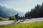 Zwei Radfahrer fahren auf einer Straße in den Bergen.