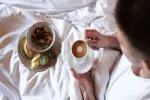 Frühstück auf Bett mit Kaffee und Gebäck