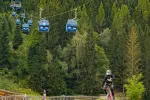 Bergbahn auf einer Waldstraße mit Biker im Vordergrund