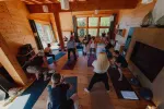 eine Gruppe praktiziert Yoga in einem geräumigen Holzstudio