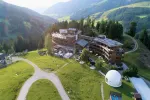 Luftaufnahme eines Berghotel mit grüner Umgebung.