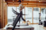 Person joggt auf einem Laufband in einem Holzgym