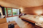 Helles Schlafzimmer mit Holzdekor und Blick ins Freie