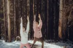 Zwei Personen dehnen sich im verschneiten Wald draußen