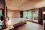 Moderner Schlafraum mit Holzwänden und großen Fenstern