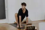 Person macht Yoga auf einer Matte in einem hellen Raum