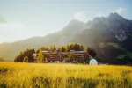 Landschaft mit einem Gebäude und Bergen bei Sonnenuntergang