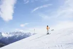 Schneebedeckte Berglandschaft mit einem Skifahrer in der Ferne