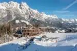 Schneebedeckte Berge und ein Skigebiet mit Gebäuden im Vordergrund