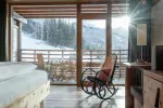 gemütliches Schlafzimmer mit Schaukelstuhl und Bergblick