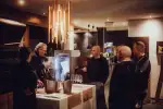 Menschen versammeln sich um einen Tisch in modernem Innenraum