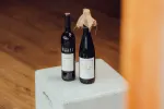 Zwei Weinflaschen auf einer weißen Box mit Holzfußboden