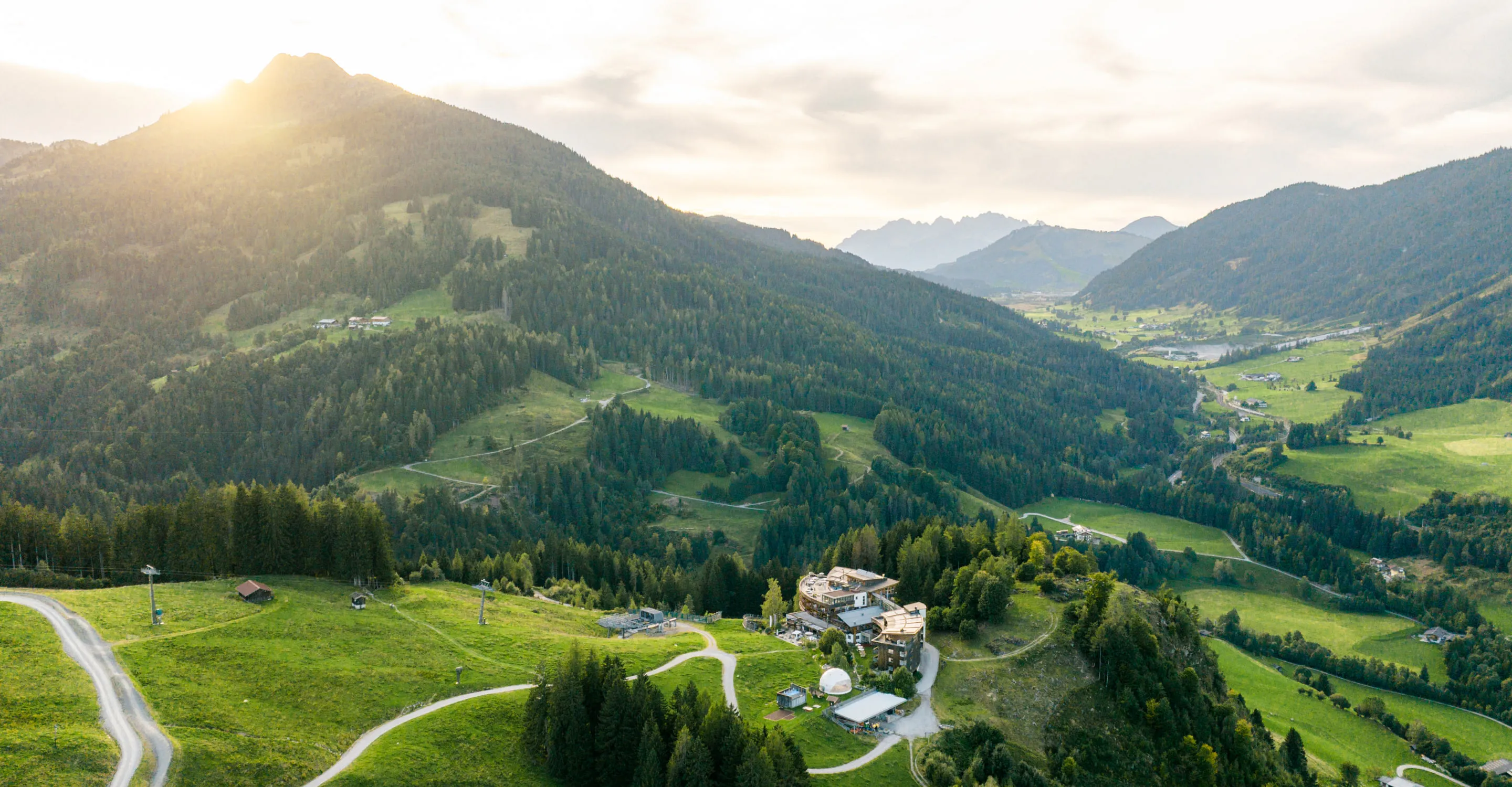 Luftaufnahme von Bergen und Tälern mit einem kleinen Dorf.