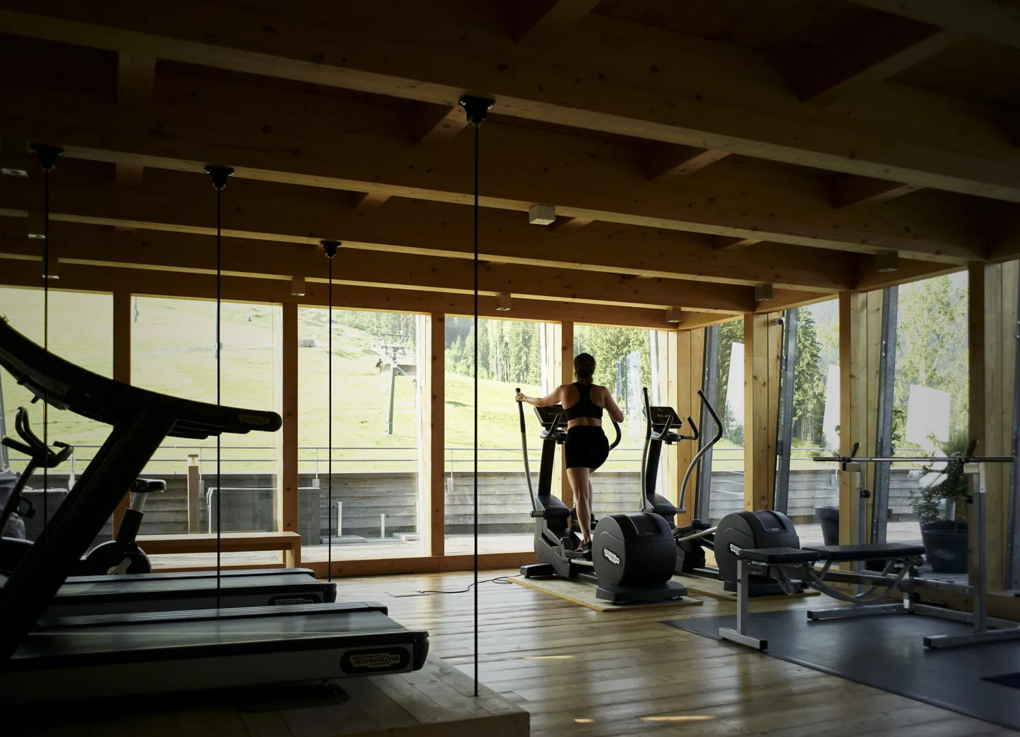 Frau trainiert im Fitnessraum mit Panoramablick