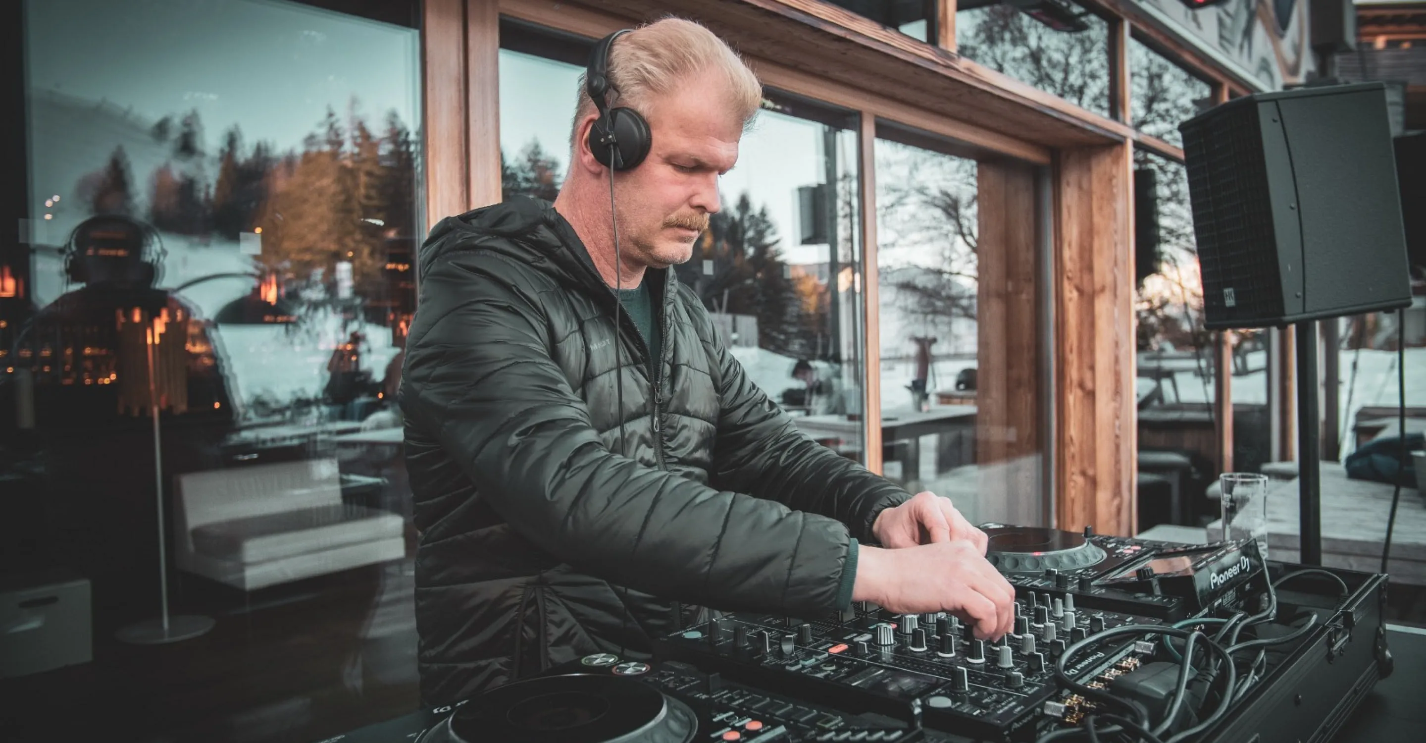 DJ an einem Mischpult in Jo Forsthofalm, moderner Stil.