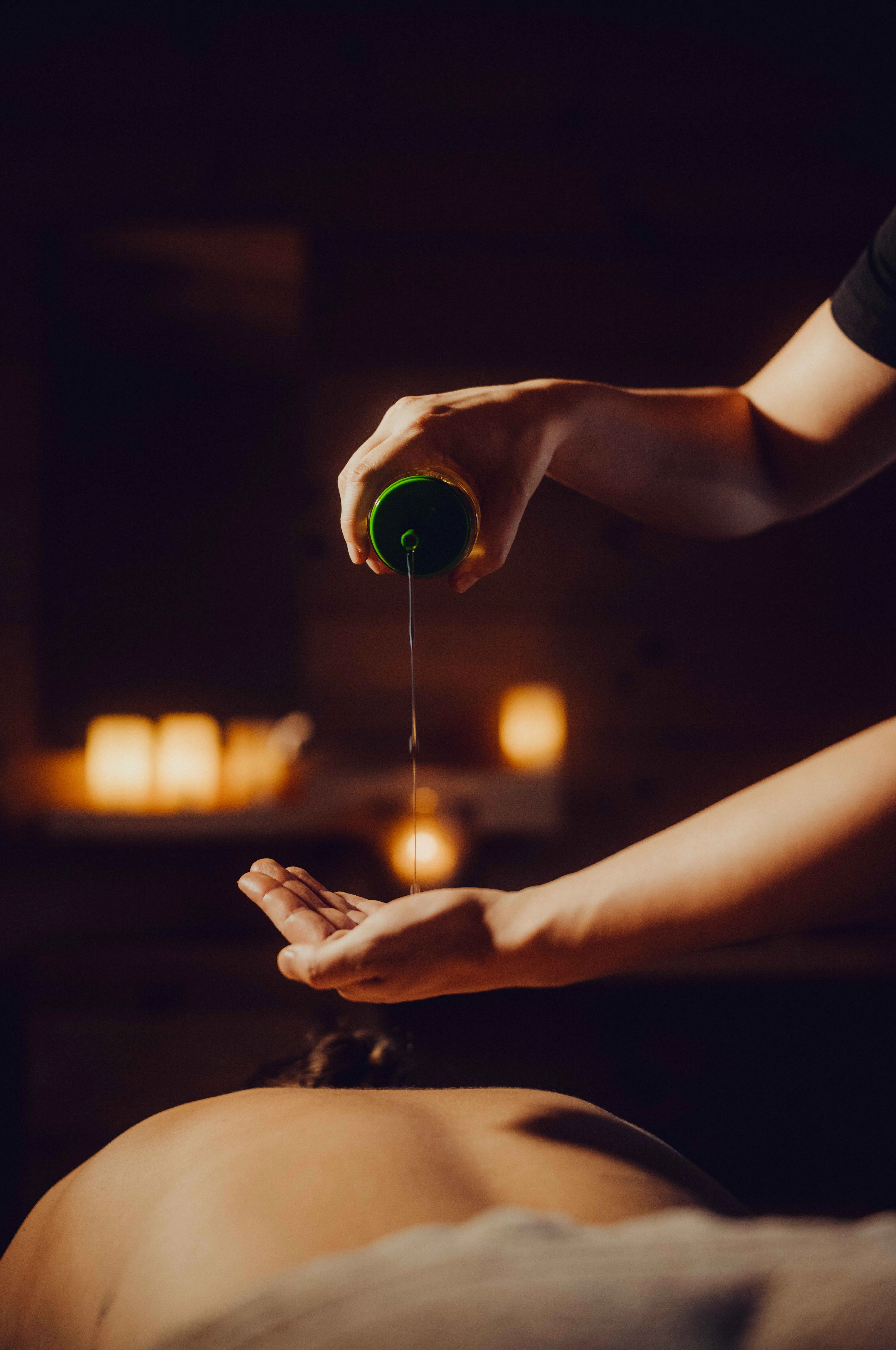 Massageöl wird in die Hand gegossen