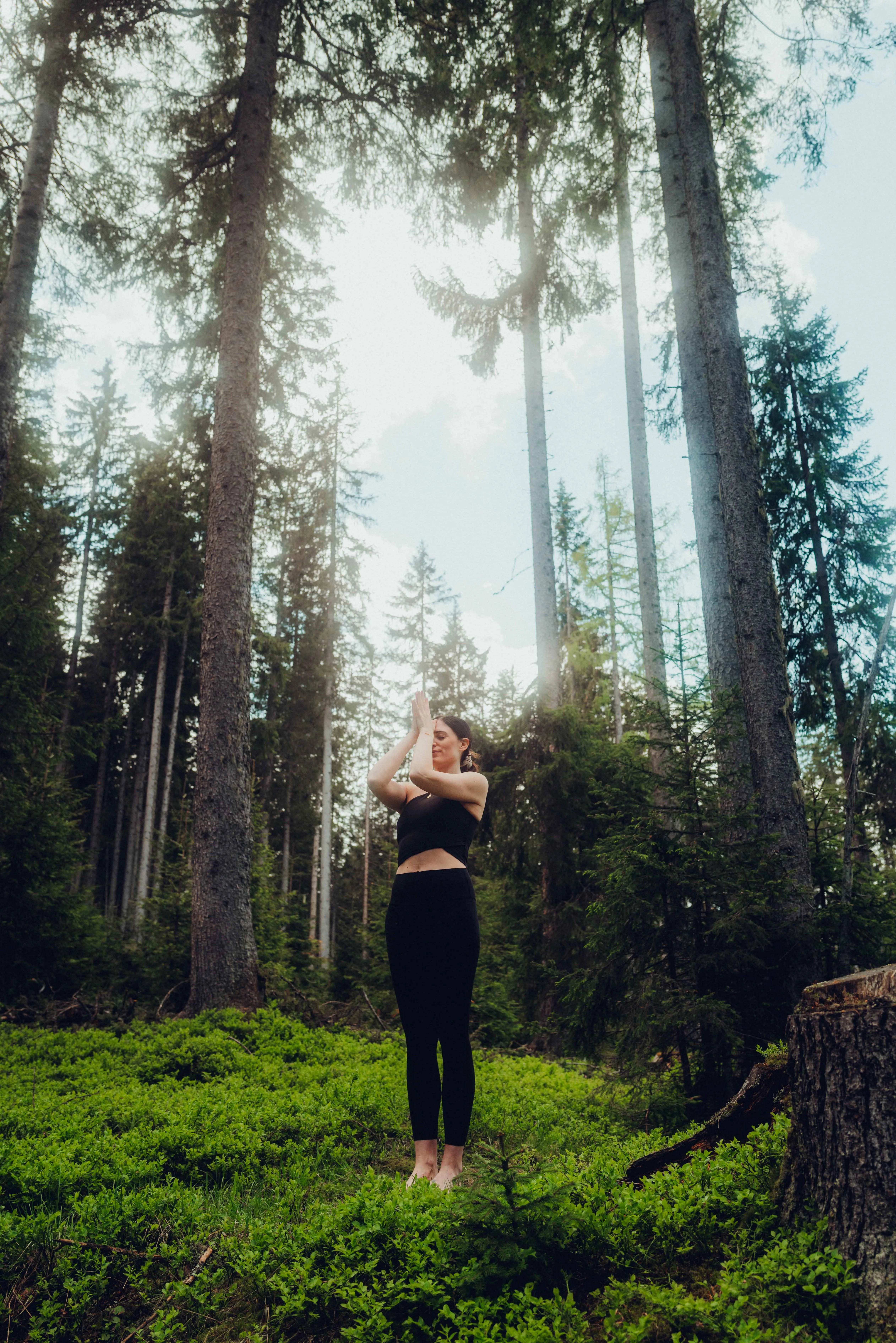 Frau praktiziert Yoga im Wald