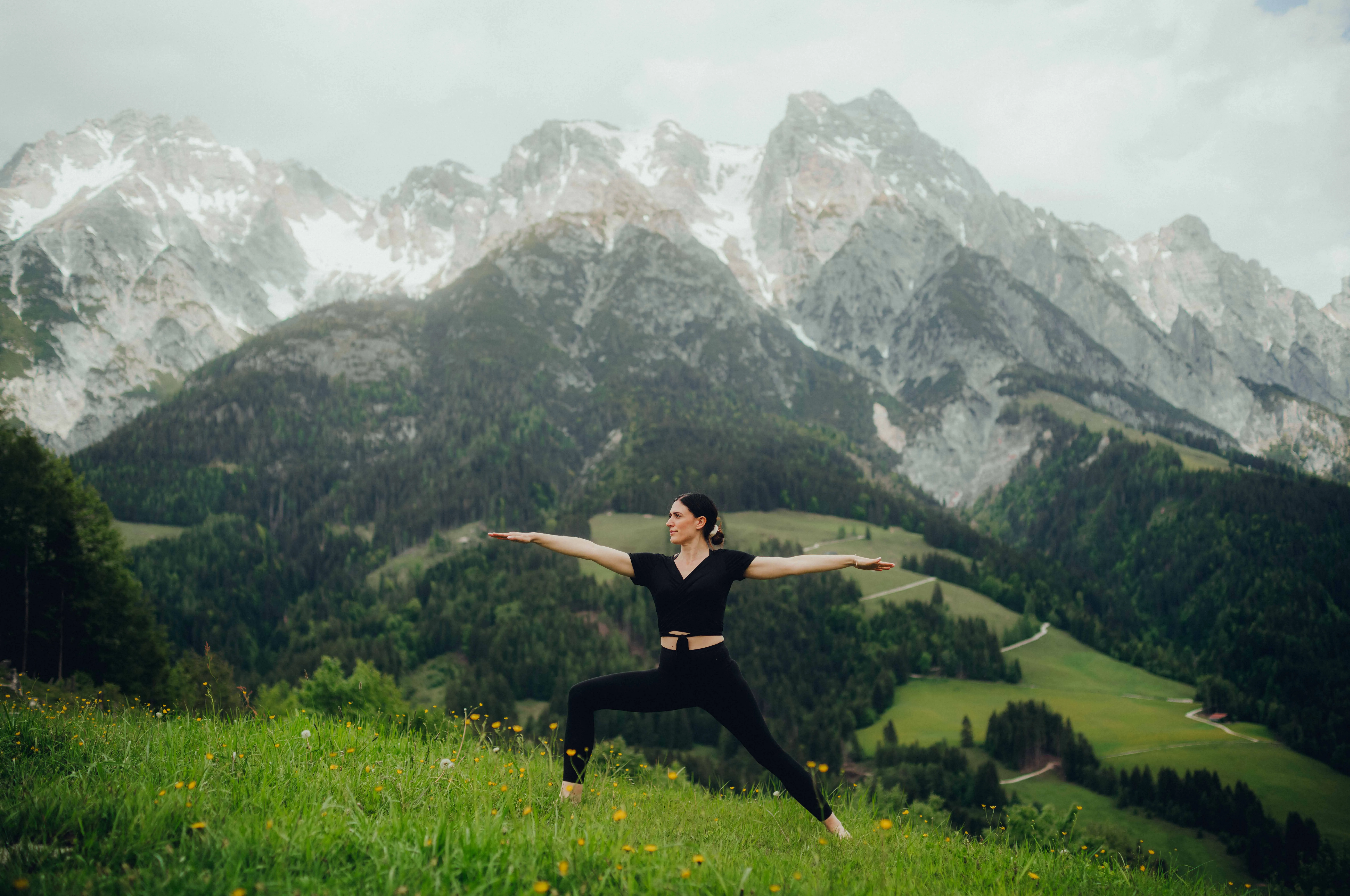 Frau praktiziert Yoga vor Bergkulisse